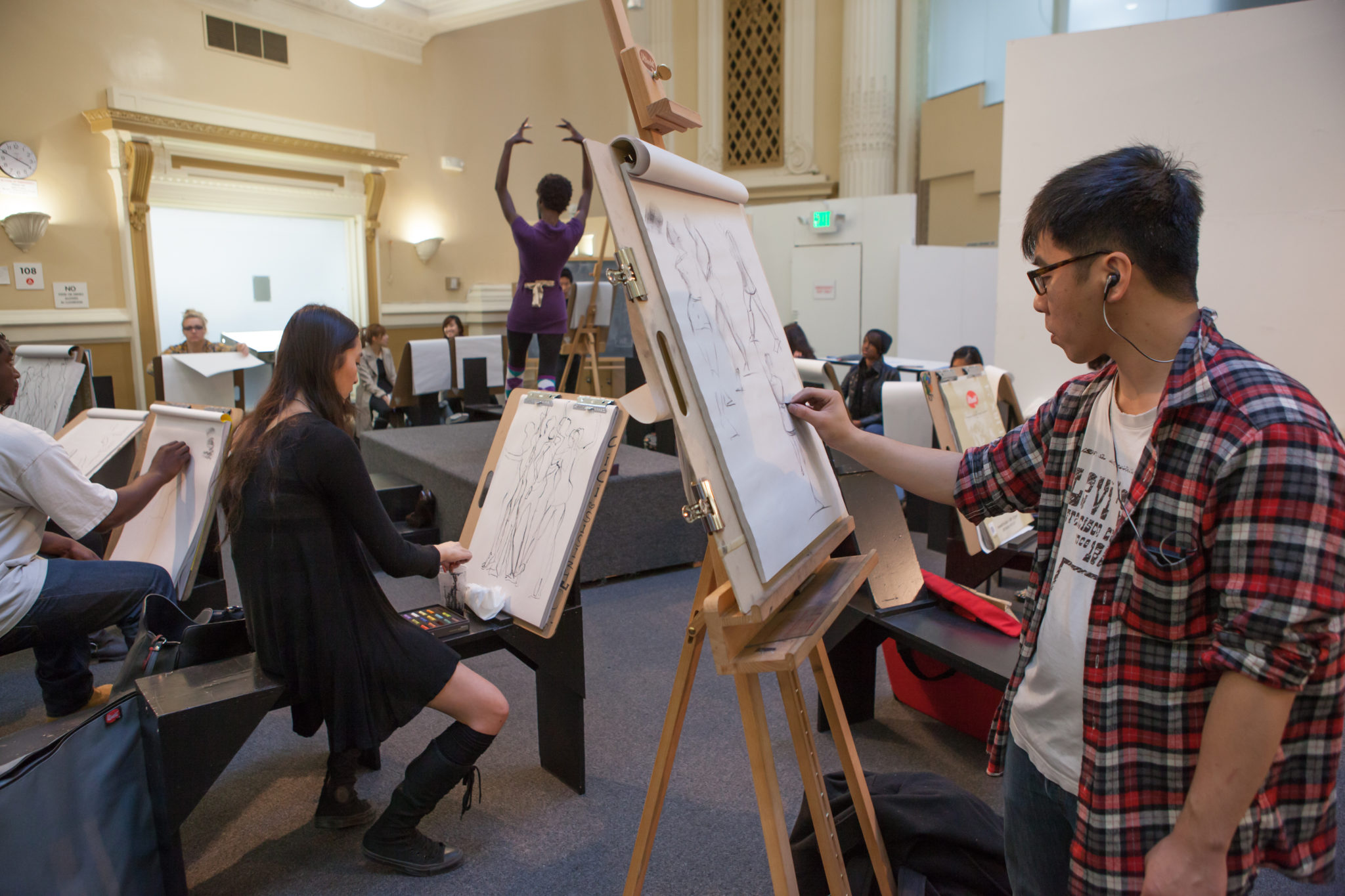 Sketchbooks and art supplies spread across a shared table